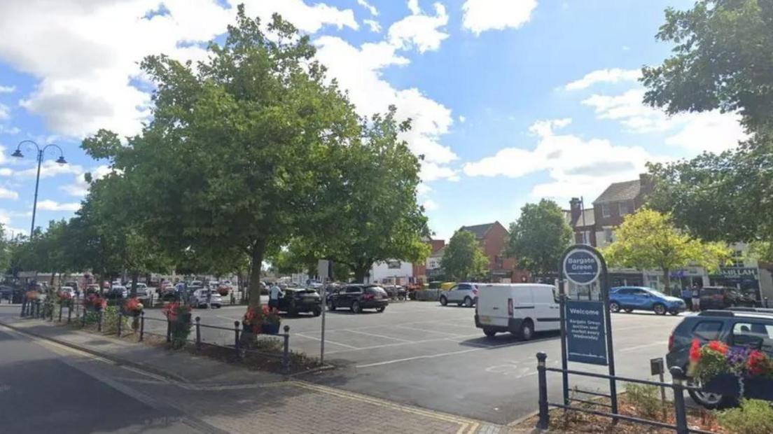 The entrance to Bargate Green car park surrounded by green trees with multiple cars parked