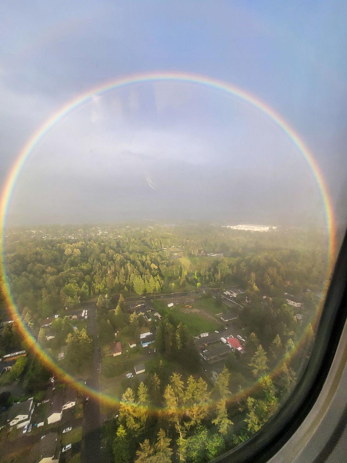 Circular Rainbow and land below captured from a plane window