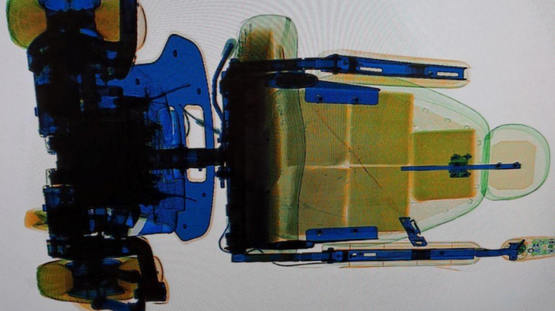 A bird's eye view scan of the electric wheelchair shows several packages in the seat.