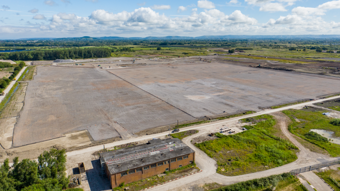 aerial photo of a brownfield site of flat land with green vegetation around the perimeter