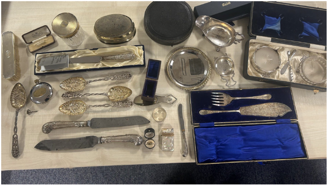 a collection of antique silverware laid out on a table