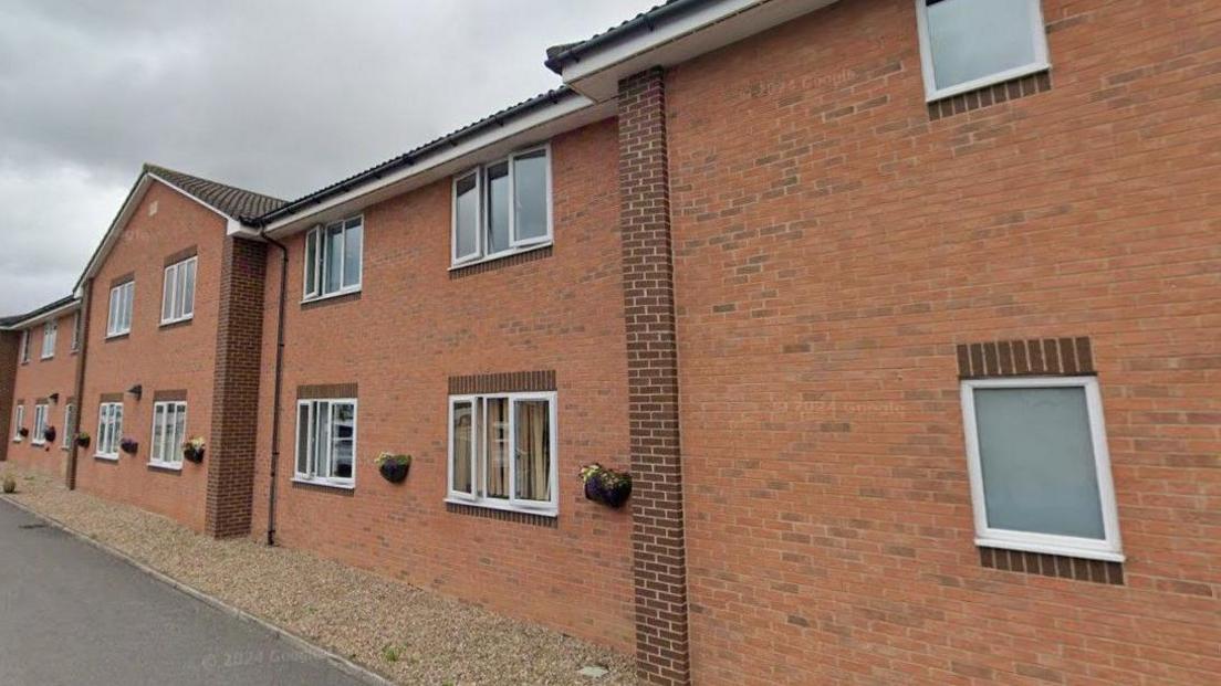 The outside of recently built care home. The two-storey building features lots of windows and flower boxes.