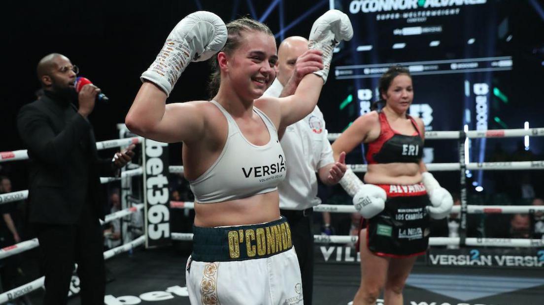 Georgia O'Connor smiles as her hand is rasied