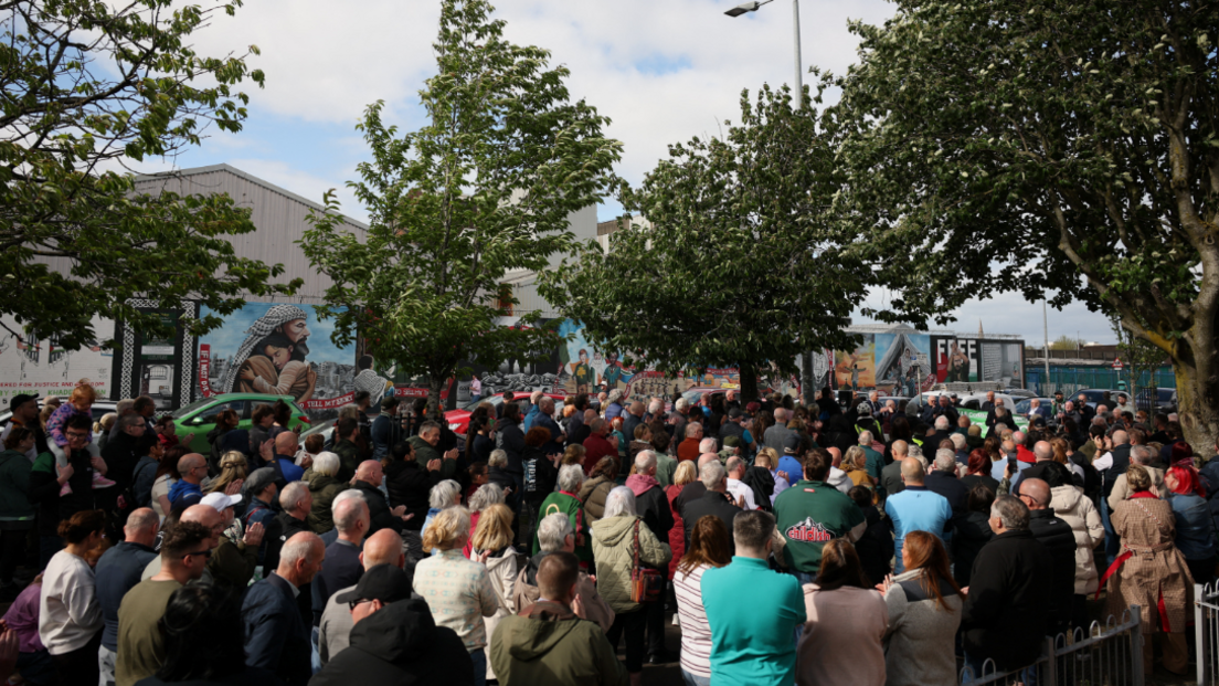 A large crowd of people are gathered outside for a rally. 