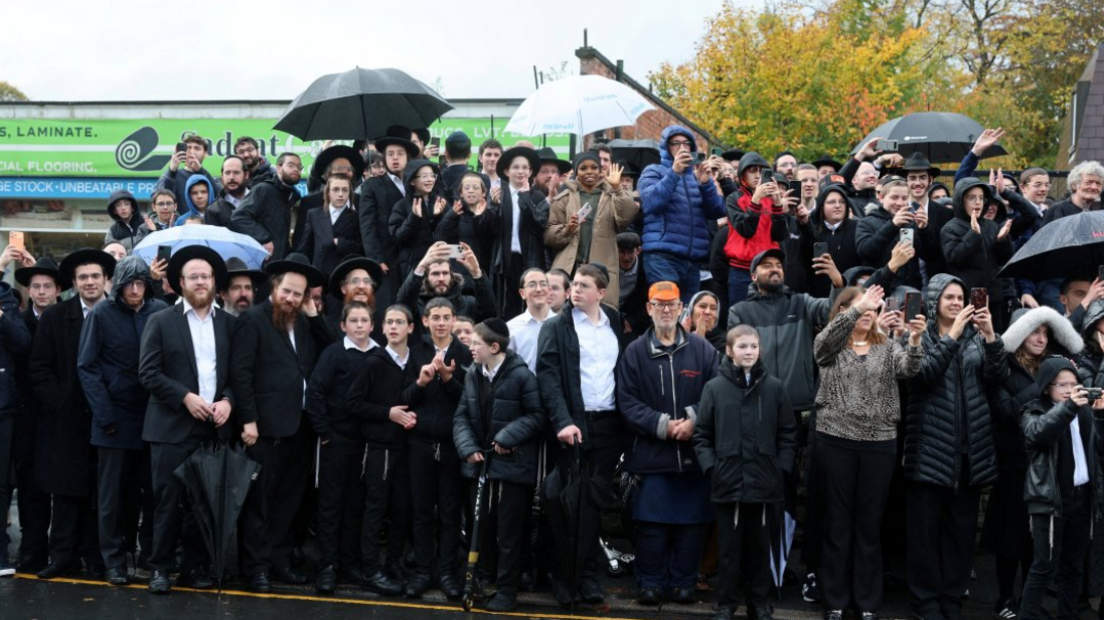 Onlookers with umbrellas in a large group photo