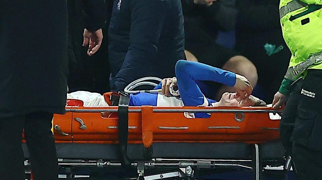 Birmingham City striker Jay Stansfield holds his face whilst being takne off off the pitch on a stretcher during the Vertu Trophy tie against Bradford City