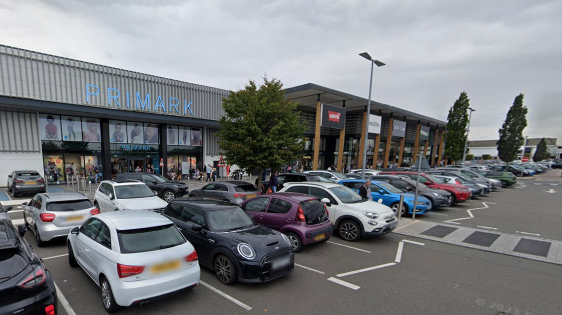 Rows of parked cars in front of shop units at Fosse Park