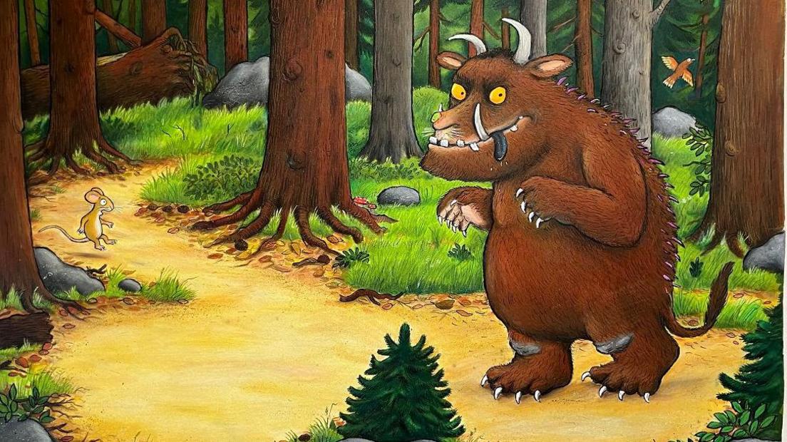 Axel Scheffler's illustration of the Gruffalo. The Gruffalo looks like a buffalo and has brown fur, yellow eyes, white horns and sharp teeth and nails. He is walking through a forest.