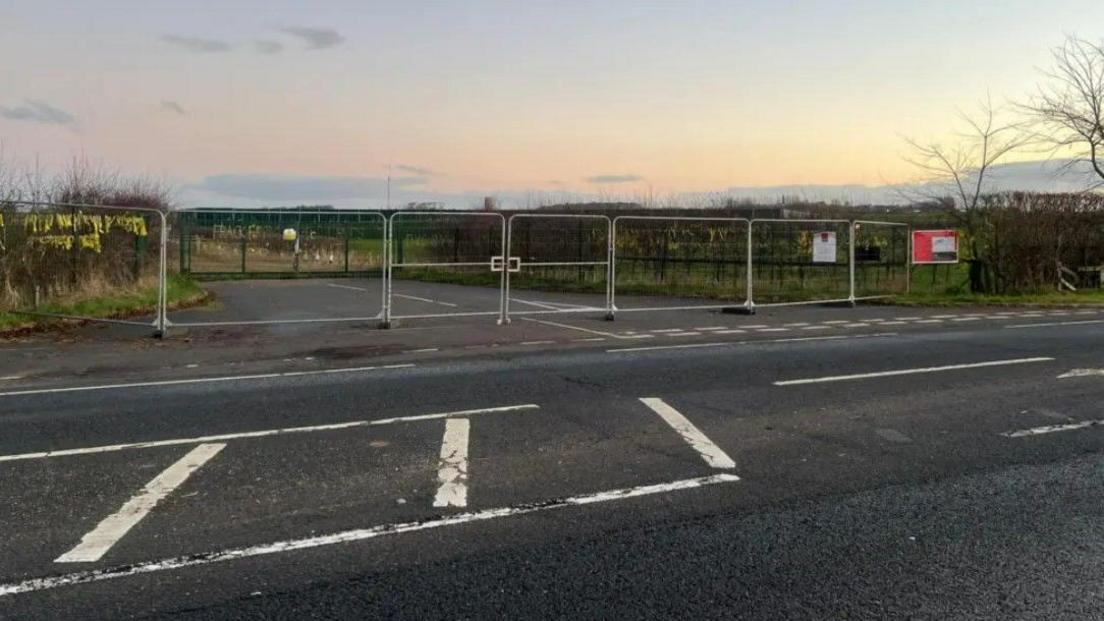 The entrance to Cuadrilla's site on the A583 Preston New Road between Preston and Blackpool showing fences blocking off the entrance and fields in the background.