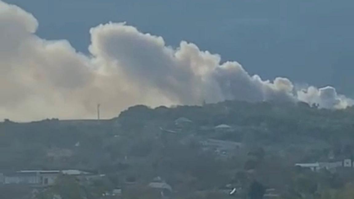Smoke billows from a rural landscape in Crimea