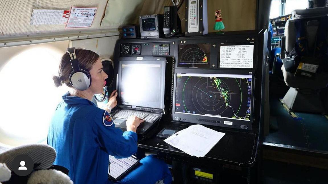 Lt Kerri Englert, a flight director for the Hurricane Hunters, at work on a previous mission.