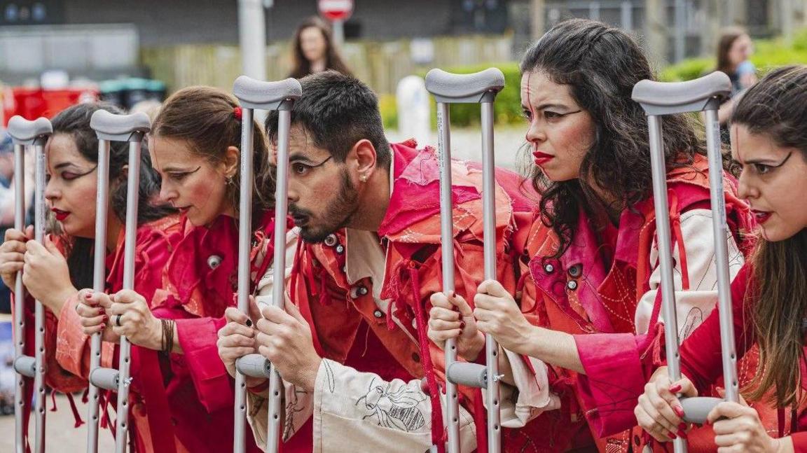 Dancers performing with crutches 