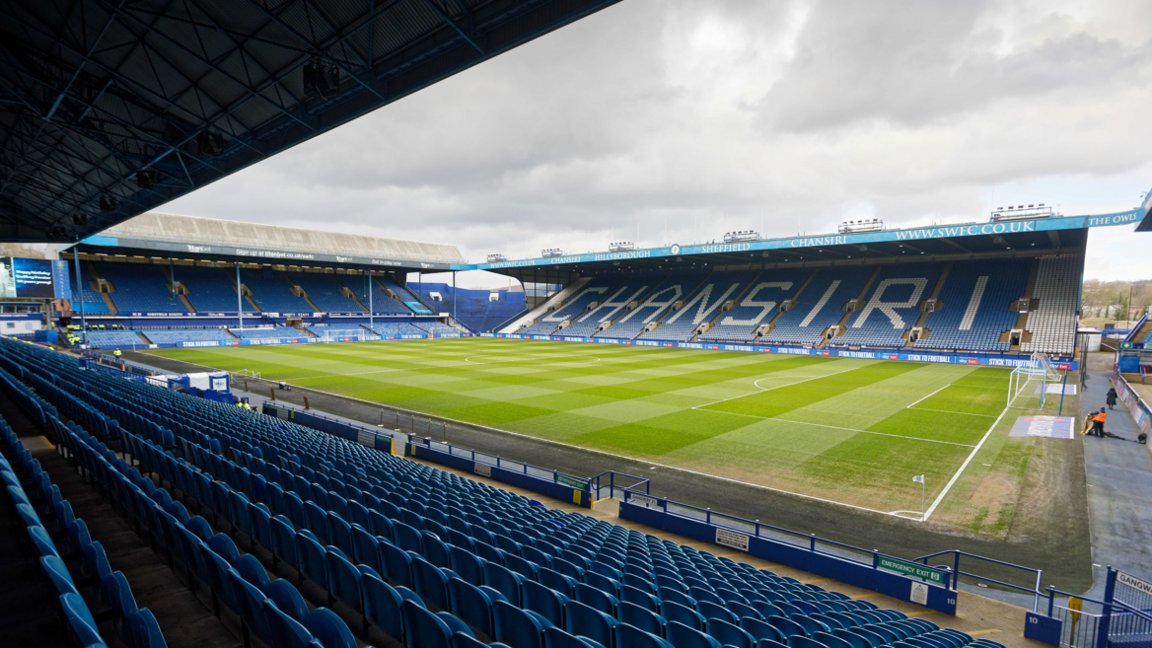 Hillsborough stadium from one of the stands with blue chairs surrounding the pitch