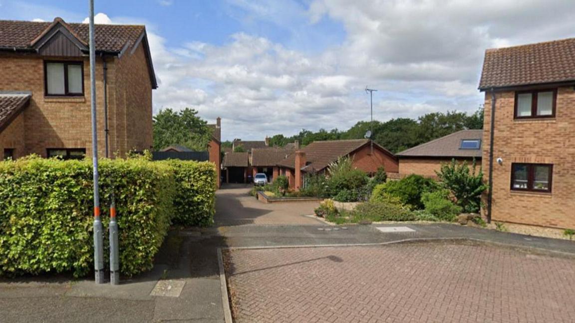 A Google Maps street view image of a cul-de-sac. A bungalow is in the background while two homes are in the foreground.