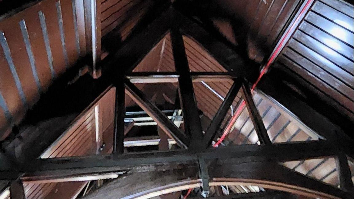 Inside a vaulted roof - dark wood beams and trusses