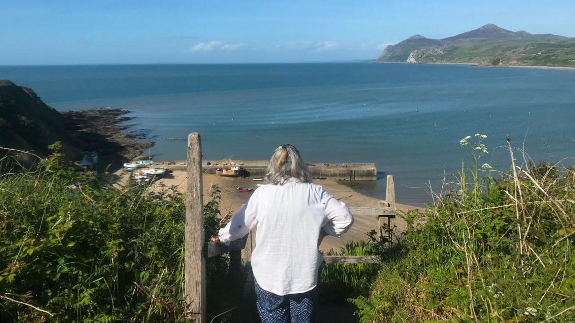 Mam Lois yn edrych dros draeth Nefyn