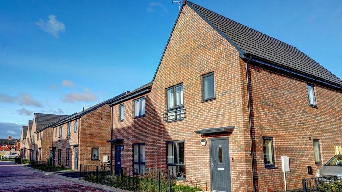 Row of new build houses with grey front doors