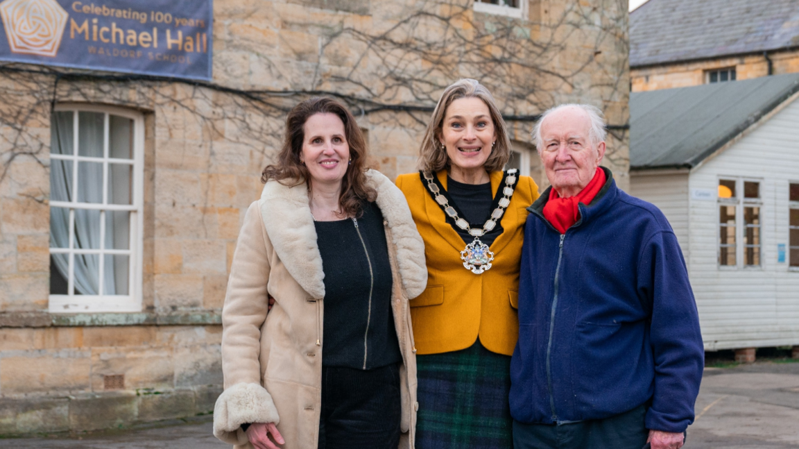 Tali Michaels, Chair of Trustees at Michael Hall, Jessika Hulbert, Chair of Wealden District Council and former Michael Hall student Stephen Sheen were among the attendees. Tali, on the left, is wearing a long beige coat with puffed collar and sleeves. Jessika, in the middle, is wearing a blue/green tartan skirt and yellow jacket. Stephen, on the right, is wearing navy trousers, a royal blue jacket and navy trousers. 