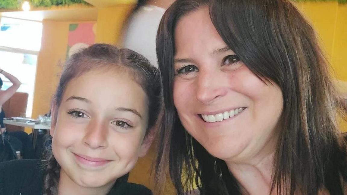 (L-R) Tallulah aged nine and her mum Lucy smiling at the camera both have hazel eyes and brown hair. 