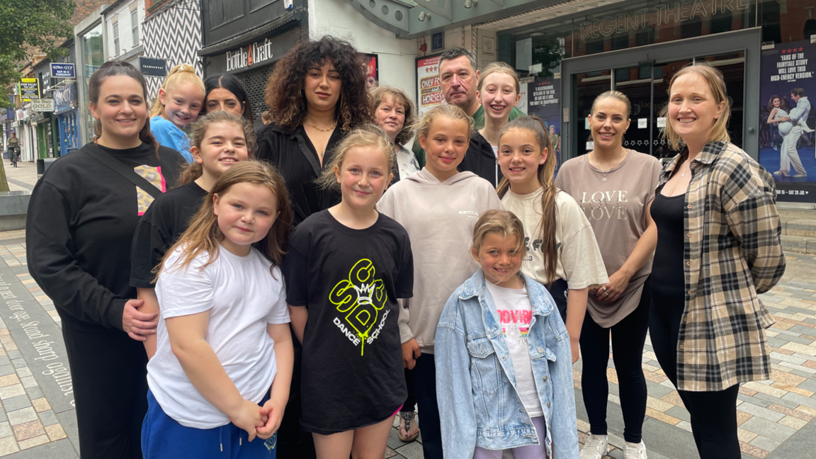 A group of children and adults from a dance group stood outside a theatre in Hanley