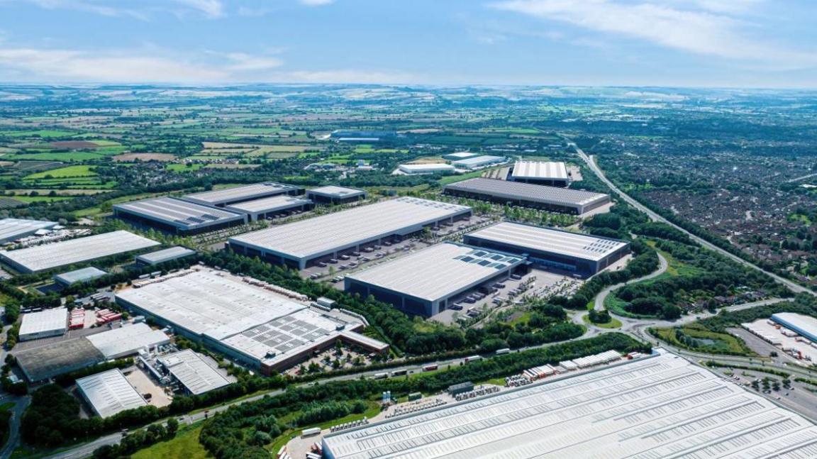 A CGI of the former Honda Site showing multiple large warehouse-style buildings in place with parking next to them. The view is from above