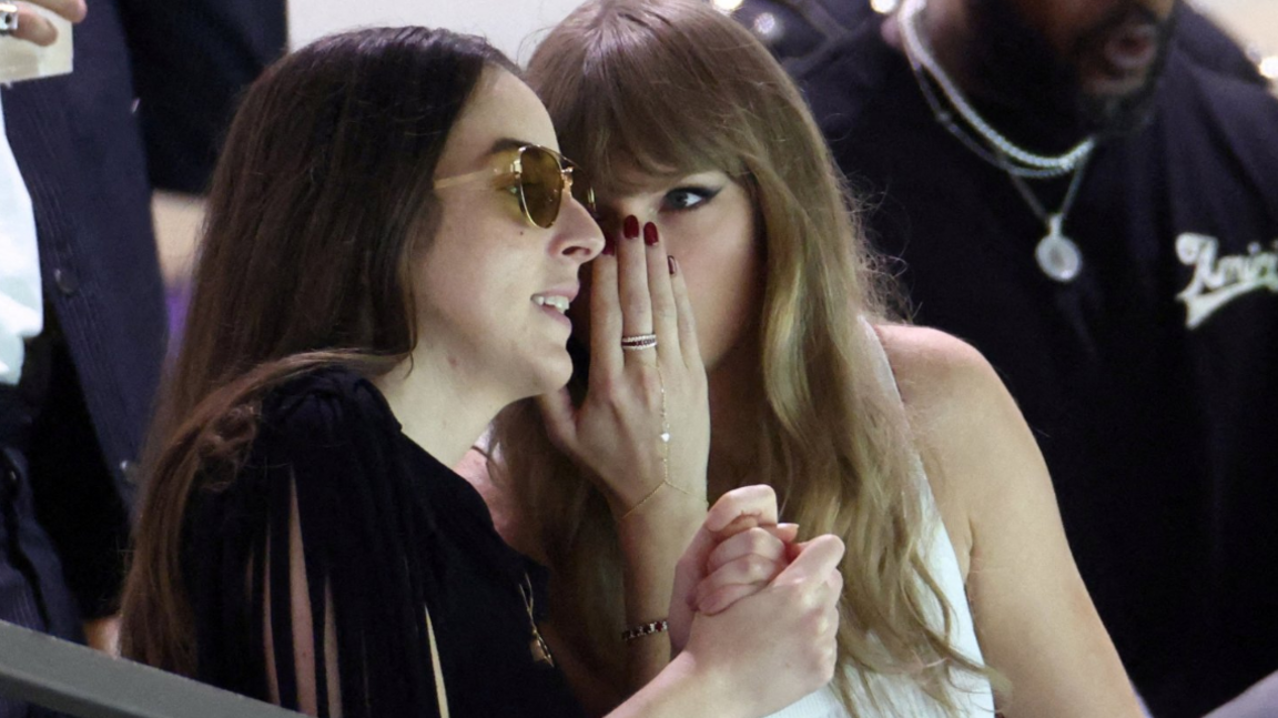 Singer Taylor Swift speaks with musician and actress, Alana Haim in the stands