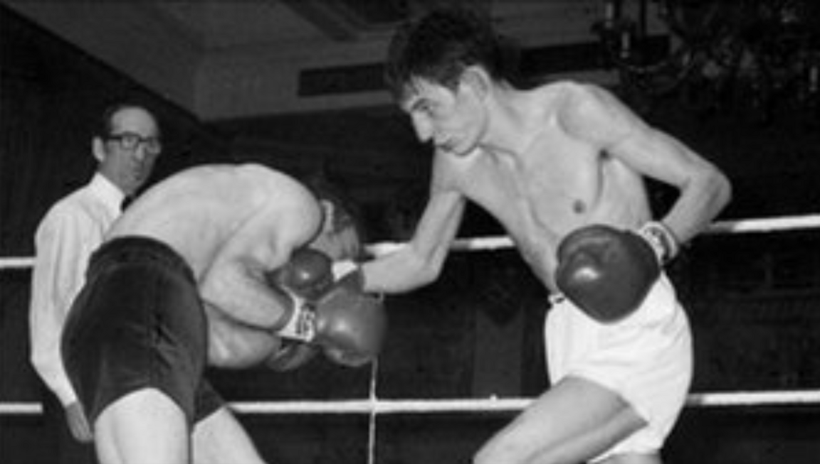 Two boxers fighting, one on the right in white shorts and on the left in black shorts