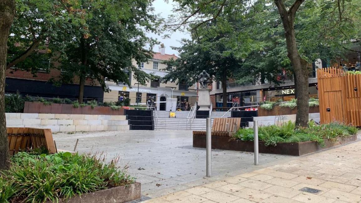 The new paving, steps and planted areas of Hay Hill, bordered by McDonald's and Next