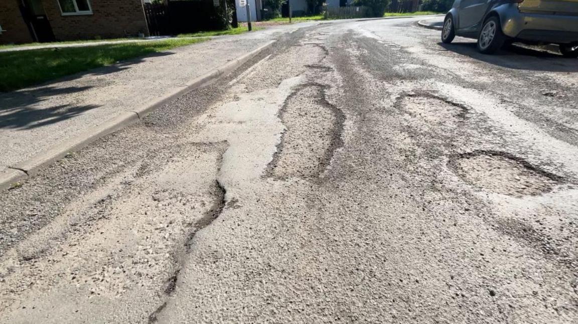 A close up showing a number of potholes in the surface of Station Road in Mablethorpe.