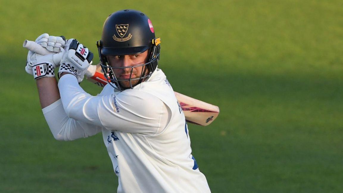 Tom Haines holding a cricket bat