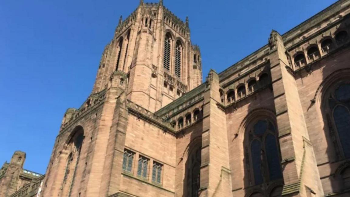 An outside view of Liverpool Cathedral with clear blue skies above it