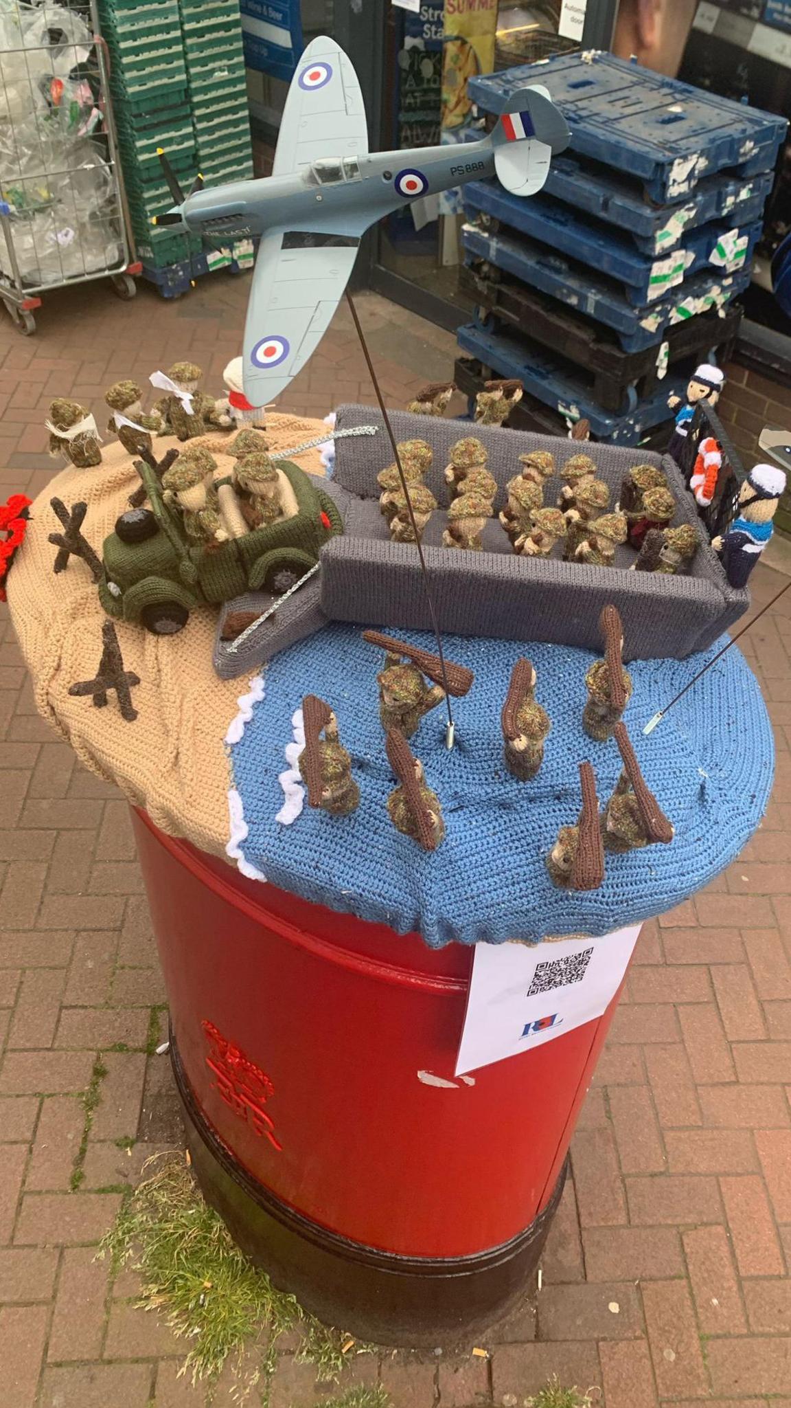 Knitted scenes from D-Day on top of a postbox