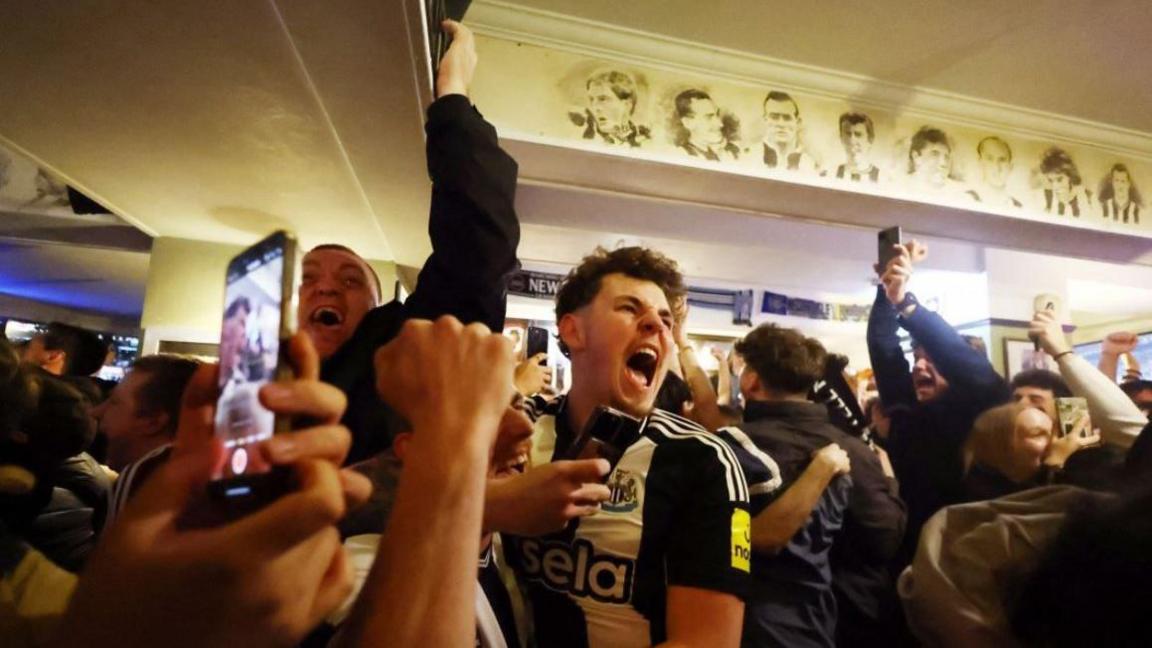 Newcastle United fans celebrate in the Strawberry pub in Newcastle after winning the Carabao Cup