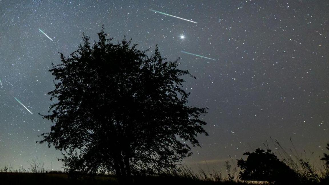 A digital stacked composition image of long exposure photos shows the Perseids meteor shower crossing the night sky over Herrnleis, Austria, early 14 August 2023