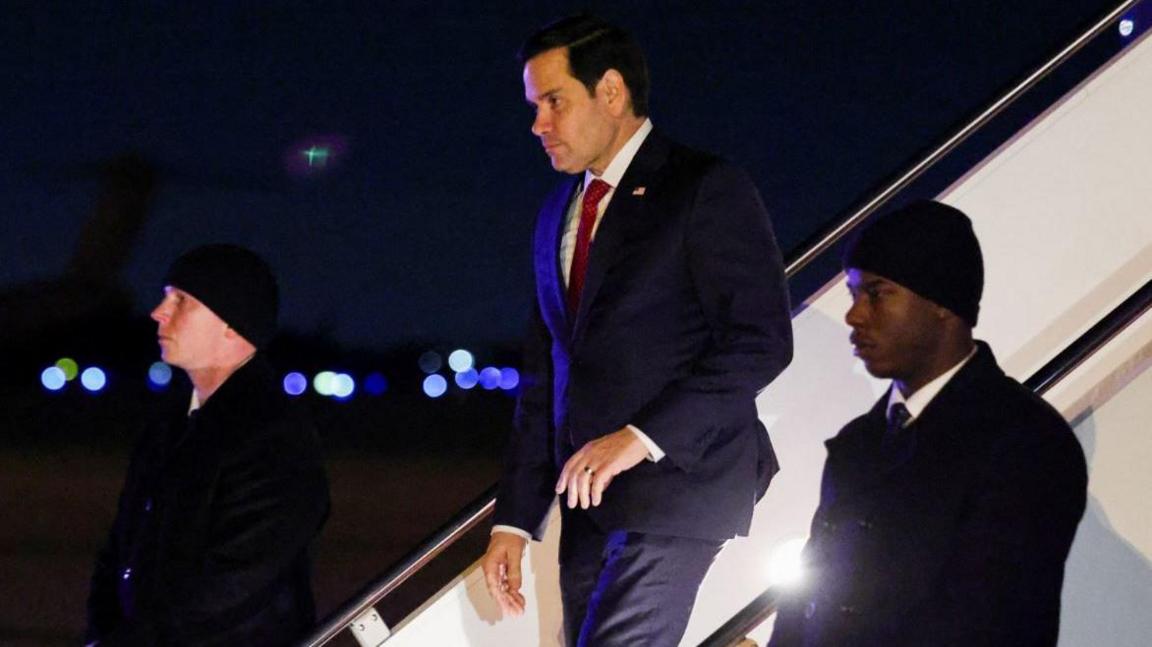 Marco Rubio disembarks a plane as he returns to Andrews Air Force Base, 13 February