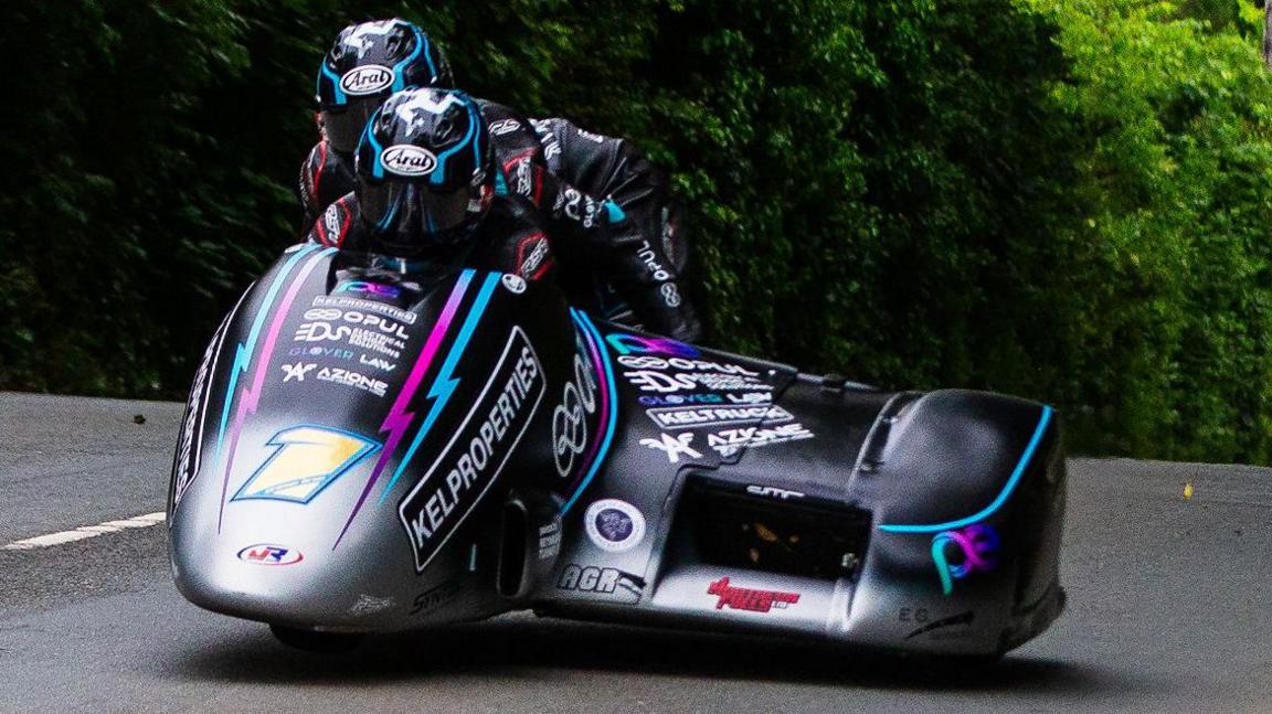 The Crowe brothers on their silver and black outfit that has pink and blue edged branding and the number one on the front.