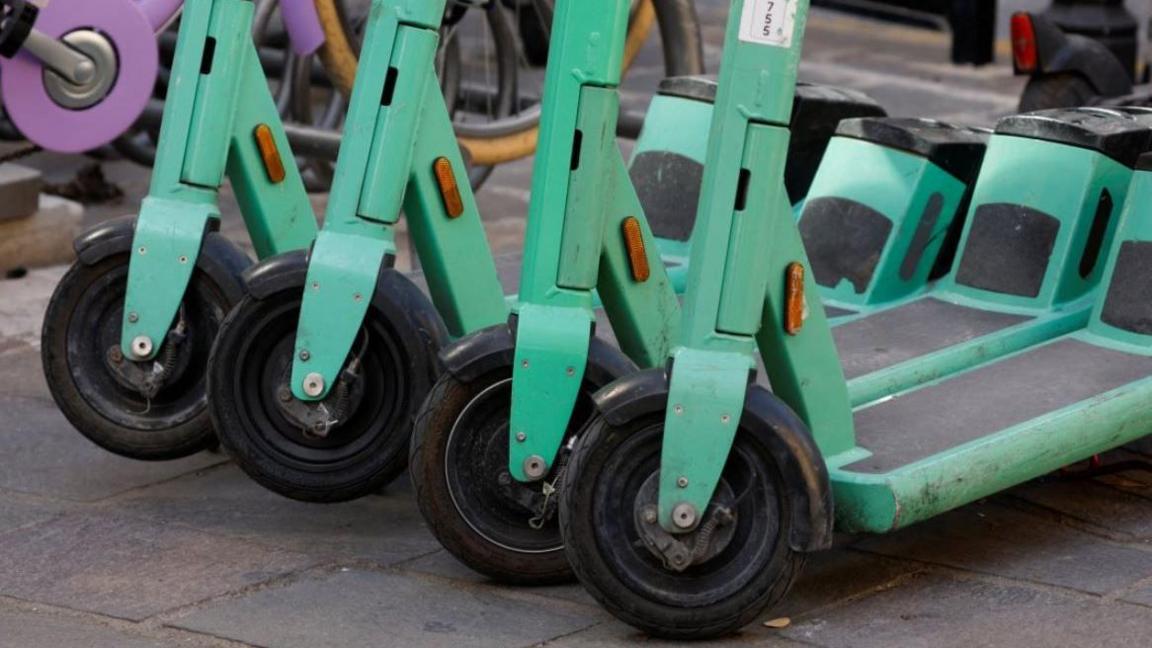 A row of green e-scooters