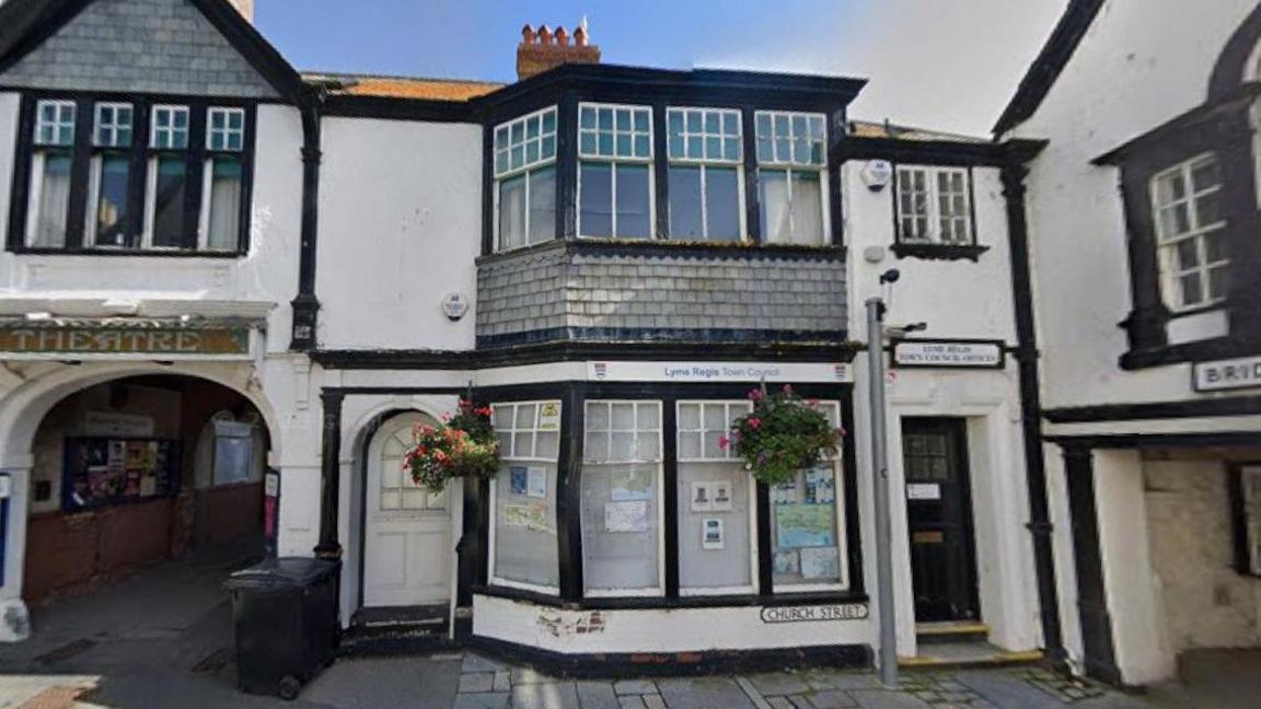 Google Street View of Guildhall Cottage - an old, terraced, two-storey, black and white building with bay windows on both the ground and first floor.