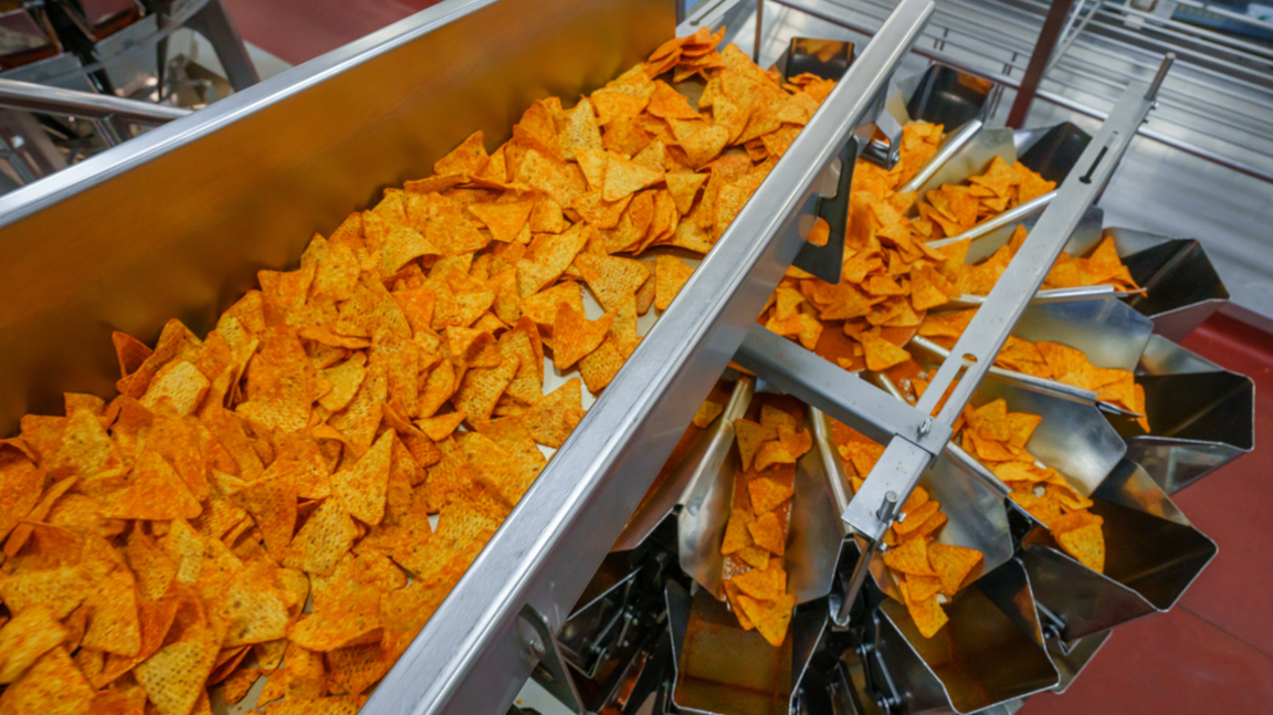 Doritos on a factory assembly machine, they are being split into separate funnels