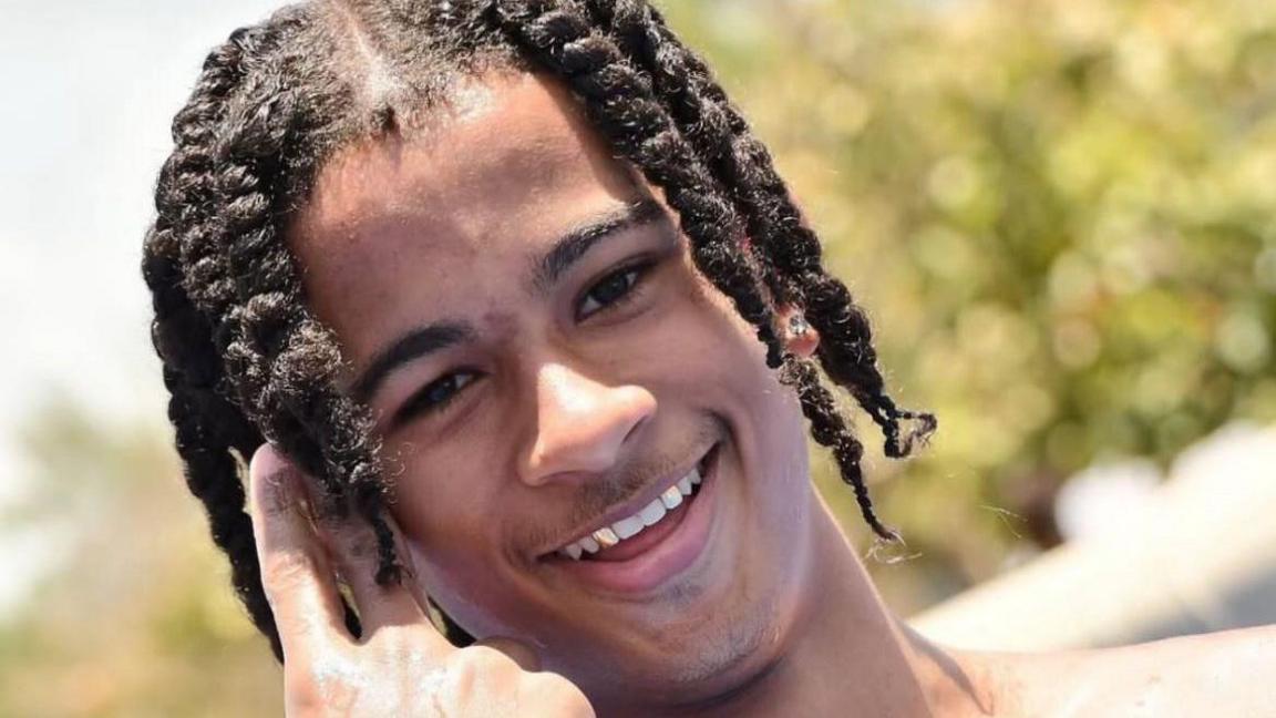 A teenage boy smiling in the sunshine