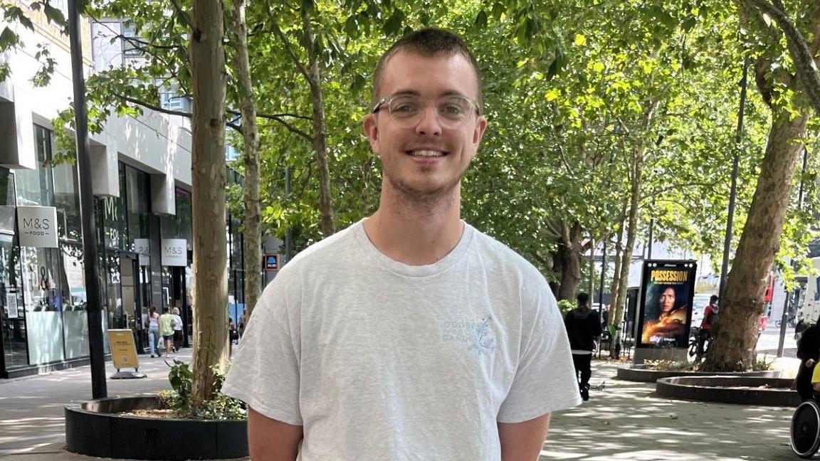 Jack, 26, stands on a UK high street