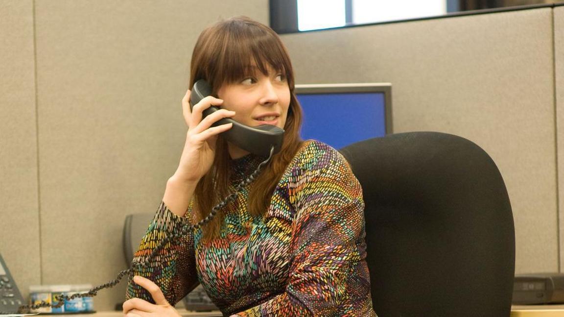 Woman in the 70s on an office phone