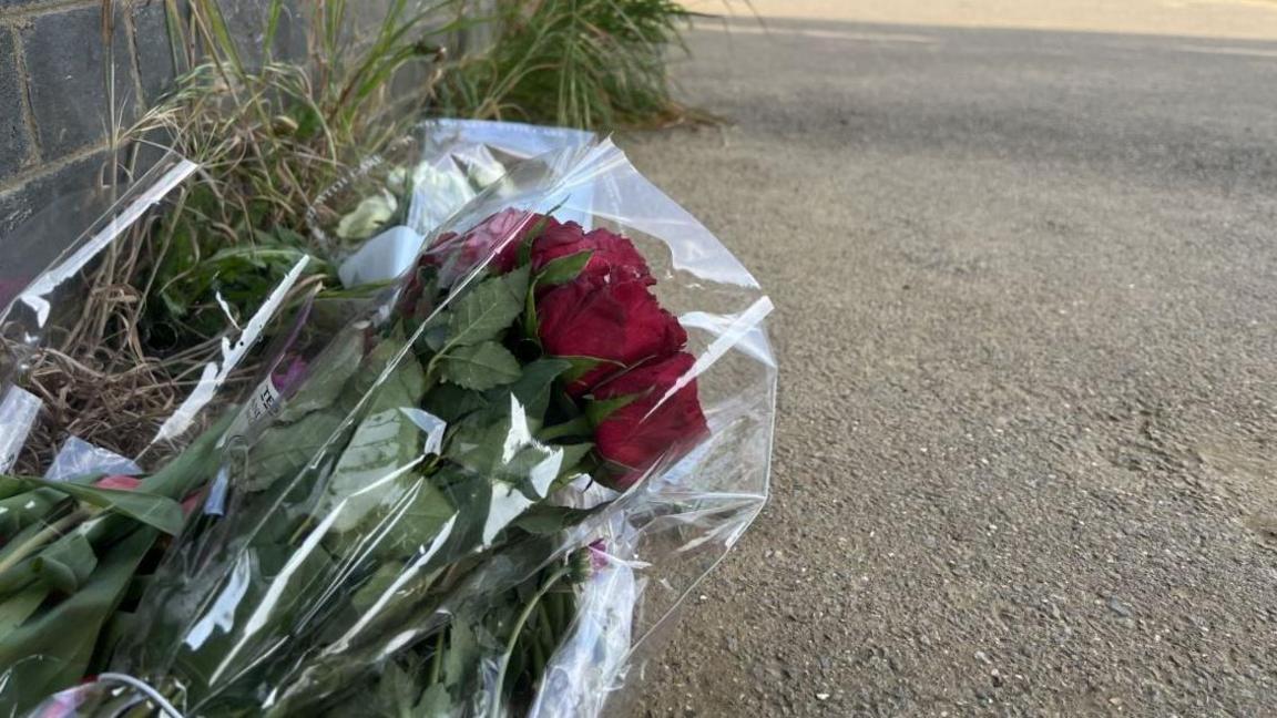 Flowers left in tribute on path