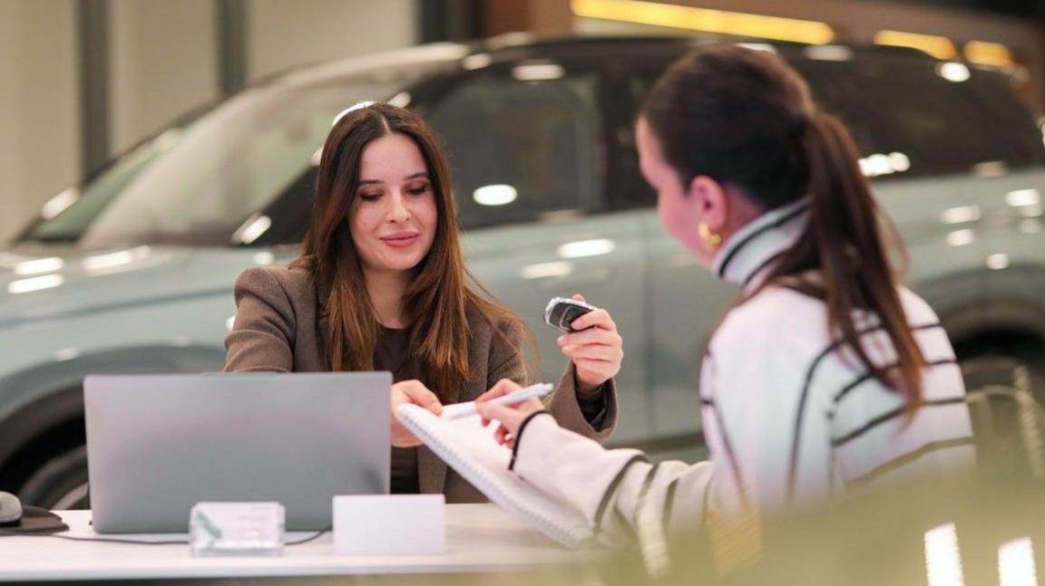 A car dealer agreeing a sale with a customer