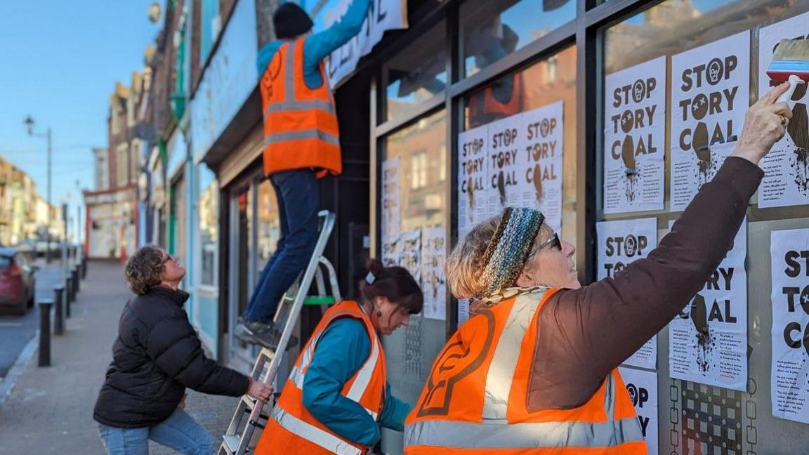 Protesters attaching posters to the windows on Friday