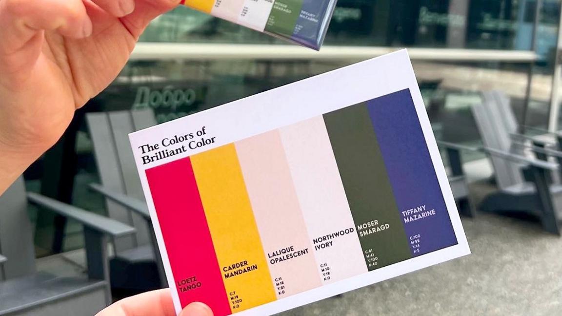 A postcard with colour strips of red, yellow, ivory, green and blue