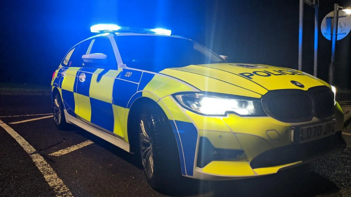 A BMW police car with its blue lights on