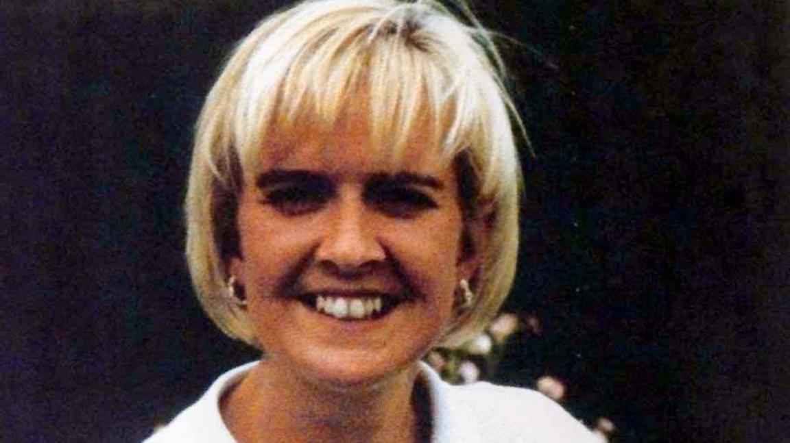 A smiling Joanne Tulip with blond hair wearing a white top.