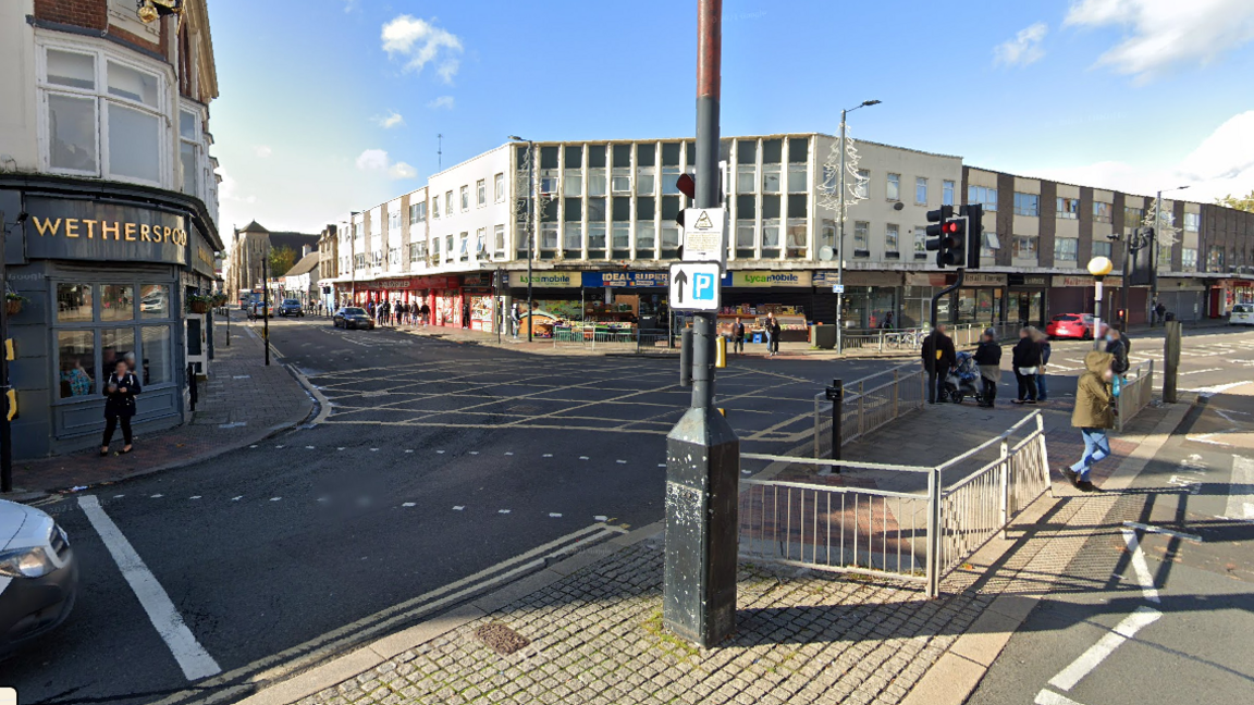 Junction of busy streets in the centre of Bedford showing traffic lights, road markings and buildings
