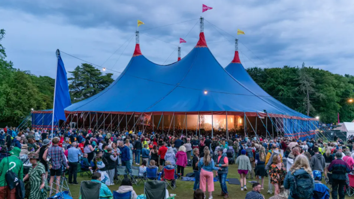 Tent mòr gorm le tòrr dhaoine a th' air cruinneachadh na broinn agus mu thimcheall oirre